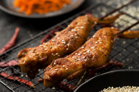 Roast chicken wings in a dark dishの写真素材