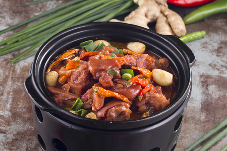 Stewed pig feet in a black potの写真素材