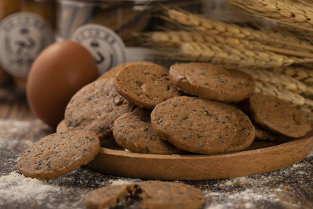 Whole wheat black sesame seed cookie in a wooden dishの写真素材