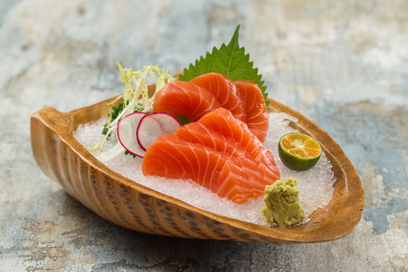 Salmon sashimi with ice in a ceramic dishの写真素材