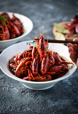 Red spicy crayfish in a white dishの写真素材