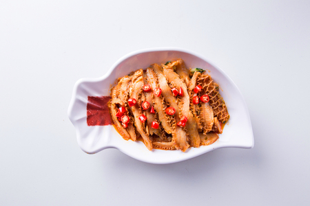 Spiced honeycomb tripe in a white ceramic dishの写真素材