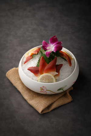 Ark shell sashimi with ice in a white ceramic dishの写真素材