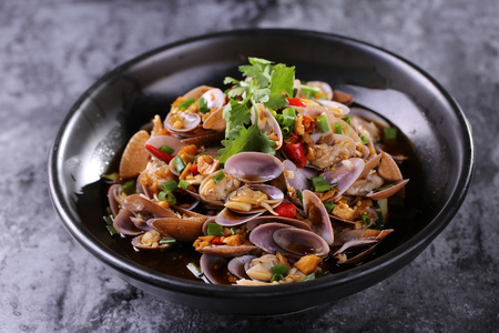 Fried fresh clams in a black ceramic dishの写真素材