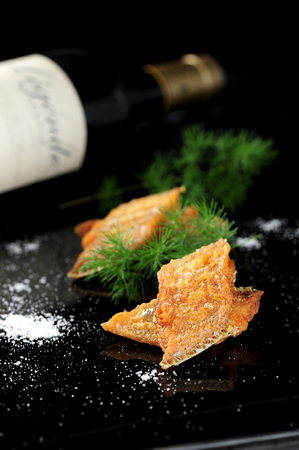 Crisp sweet hairtail pair with red wine in the dark backgroundの写真素材