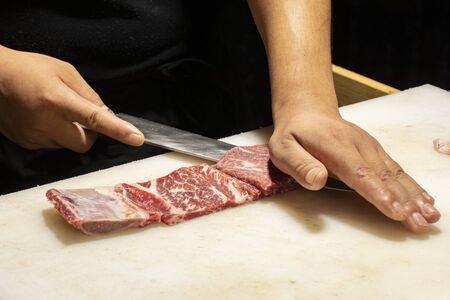 Fresh cut sliced beef on a white cutting boardの写真素材