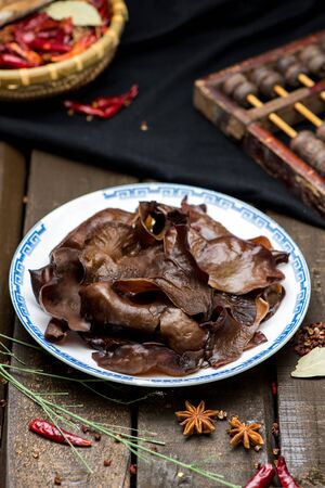 Fresh black agaric slices in a white ceramic dishの写真素材