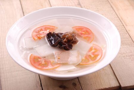 Pork and radish soup in a white ceramic dishの写真素材