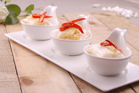 Chili peppers garnish baby vegetables in the white ceramic dishの写真素材