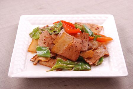 Double cooked pork slices in a white ceramic dishの写真素材