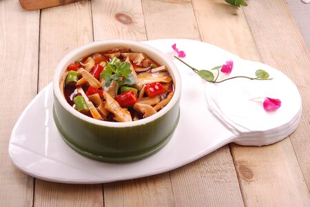 Pork slices in red oil in bamboo tube in a white ceramic dishの写真素材