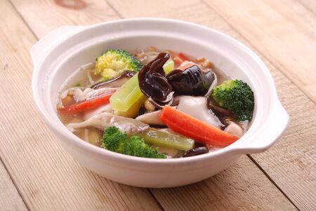 Fresh greens in clay pot in a white ceramic dishの写真素材