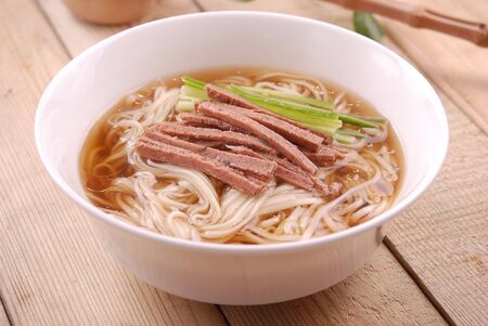 Noodle soup with arhat fungus in a white ceramic dishの写真素材