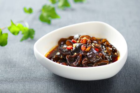 Cold black fungus with vinegar and chili in a white ceramic dishの写真素材