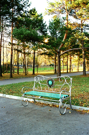 in the autumn Park at sunset bench with a clockの写真素材
