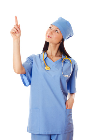 Young female doctor pointing finger upwards isolated on white backgroundの写真素材