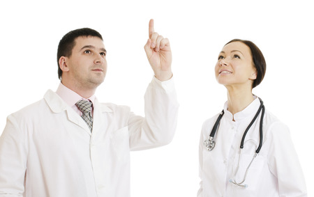 Two doctors male and female  pointing finger upwards. Isolated on white.の写真素材