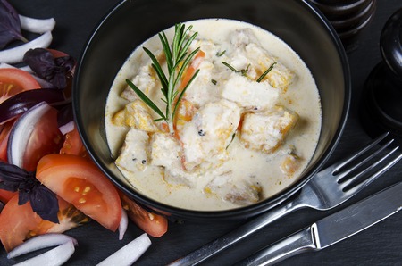 Braise fillet slices of turkey, chicken in a creamy sauce with vegetables. Black background.の写真素材