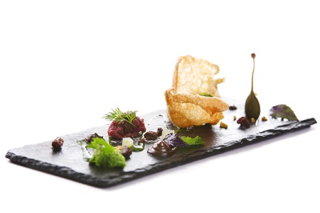 Molecular modern cuisine. Chips Pigskin with tartare or carpaccio of beef. Stock image. Isolated on white.の写真素材