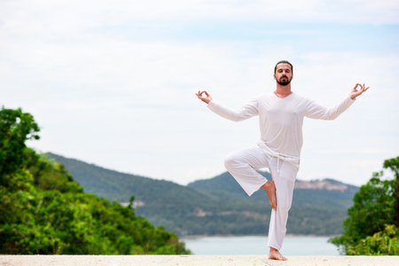 Man Doing Indian classic art Yoga at the Sea and Mountainsの写真素材