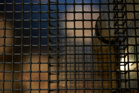 abstract background of a metal grid in front of a window at nightの写真素材