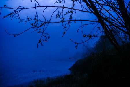 A bit spooky view of the river. The mist rises from the darkness.の写真素材
