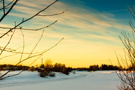 The sun sets dramatically over the frozen river of Pyhajoki in the Northern Finland.の写真素材