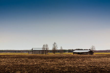 The barns on the spring fields are empty and waiting for the autumn to be filled with crops. These barns are not actually used any more but the look like they are ready for the work they were built for.の写真素材