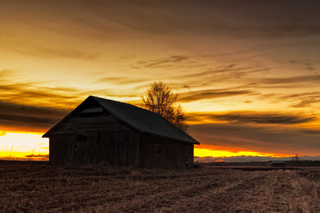 A lonely old barn house stands on the springtime fields of the Northern Finland. The sun sets...