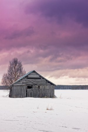 The sun is beginning to set on the winter fields of the Northern Finland. It's only early afternoon, but the days are short in the North.の写真素材