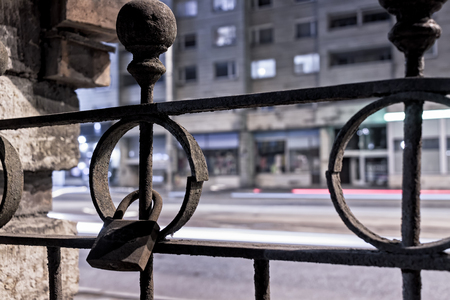 An old lock in an iron fence of an old building in Tallinn, Estonia. The lock has been there for a while. The circle around it has already broken.の写真素材