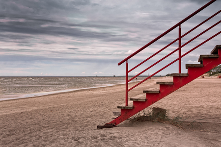 The stairs leading to the life guard tower at a beach in Pärnu, Estonia. The day is very cloudy and not so warm. The beach is almost empty.の写真素材