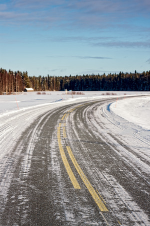 The road has been covered by ice and snow in the rural Finland. In the wintertime the roads can be very slippery.の写真素材