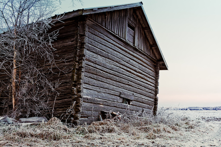 The wall of an old barn house is covered with frost on a cold morning at the rural Finland.の写真素材