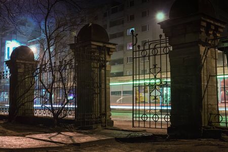 An iron gate leads to the big city lights at Tallinn, the capital of Estonia. The yard is hundred...