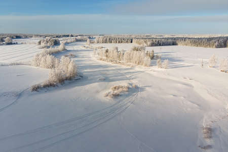 The snow on the river ice is decorated with snow mobile tracks. The frozen river is an excellent track for high speed snow mobile racing.の写真素材