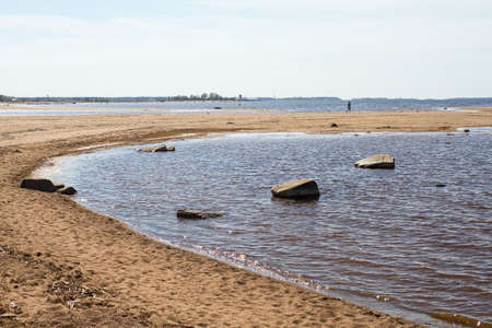 A lonely man is walking on the sand bank at Kalajoki, Finland. Usually these banks are filled with people on summer days.の写真素材