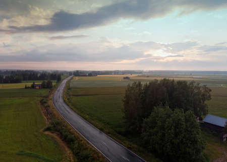 The summer sun sets over the fields. The mist is rising, when the warm soil slowly gets colder.の写真素材