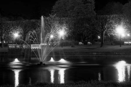 A fountain sprays the water of the Swan Lake in the Kadriorg park at Tallinn, Estonia on a quiet night.の写真素材