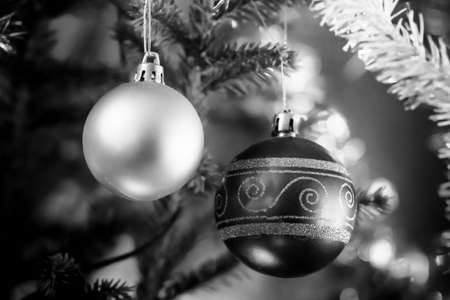 Two old fashioned baubles hanging in the Christmas tree. The baubles are very traditional and even have been dent a little bit.の写真素材