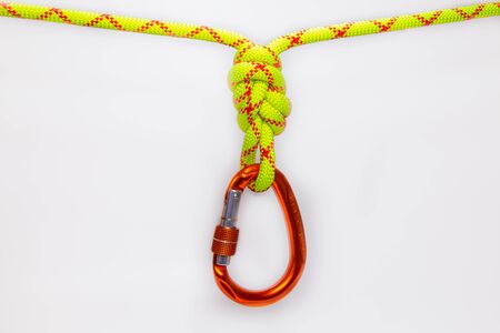New red oval touristic and alpinistic carabine hangs from double figure eight 8 knot. Stretched...