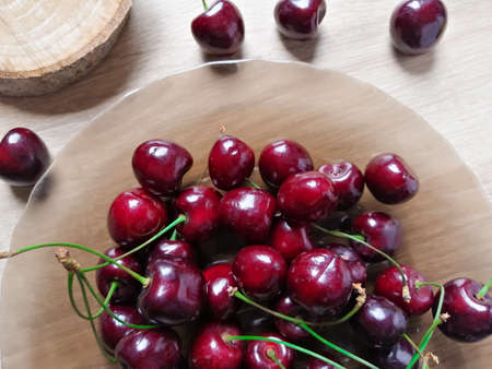 Cherries in a plate and on the tableの写真素材