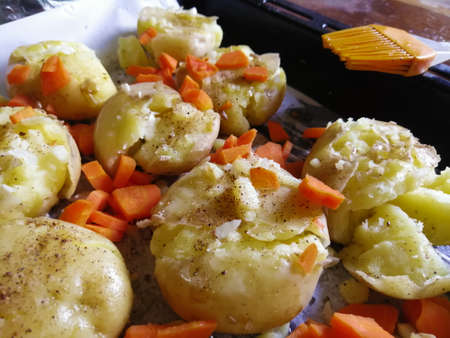 Cooking young baked potatoes with carrotsの写真素材