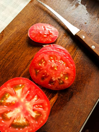 Sliced tomato on a wooden boardの写真素材