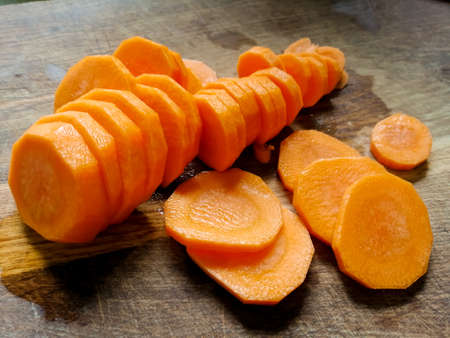 Orange carrots cut into rings on a wooden board