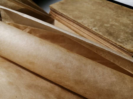 Vintage book next to twisted parchmentの写真素材