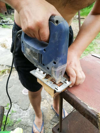 Power tools master cuts a wooden beamの写真素材