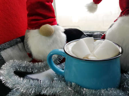 New Year and Christmas - cappuccino with foam and marshmallow in a blue cup. Next to the dwarves.の写真素材