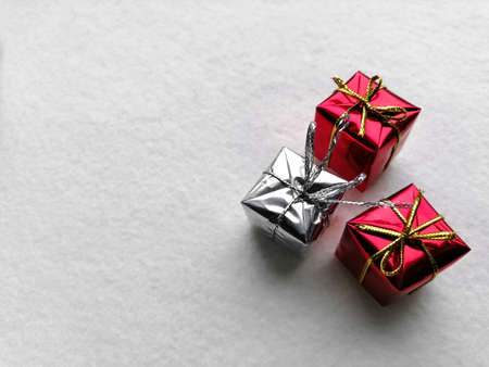Two red and one silver Christmas presents lie on a white background. Christmas and New Year.の写真素材