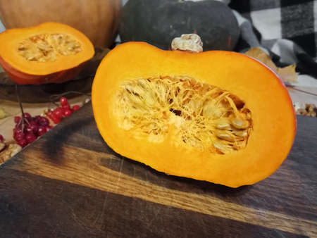 Bright orange pumpkin in section on a wooden board. autumn, useful gifts of nature.の写真素材